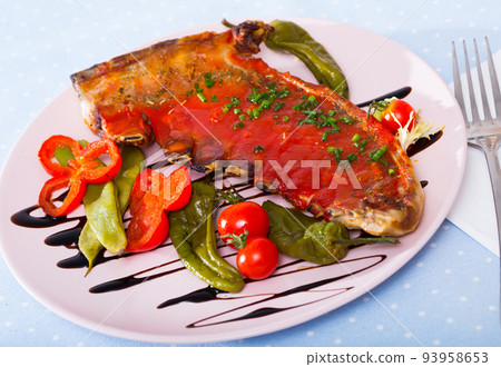 Spicy tomato sauce tasty lamb ribs served with peppers and cherry tomatoes 93958653