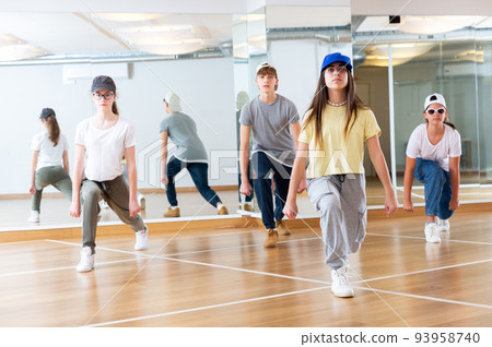Teens dancing hip-hop dance together in dance hall Teens dancing hip-hop dance together in dance hall 93958740