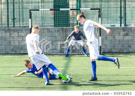Youthful football players challenging for ball 93958742