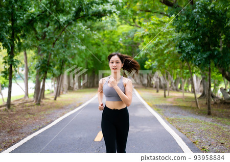 Asian woman running outdoor in public park. Female jogging on the road in morning 93958884
