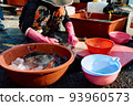 A lady handling fish at a fish market in Korea 93960573