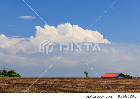 在山上的田野之外看到的紅色屋頂和雷雨 93960896