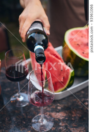 Juicy red watermelon and red wine. The concept of summer and delicious fruit. Vertical photo. Juicy red watermelon and red wine. The concept of summer and delicious fruit. Vertical photo. 93961066
