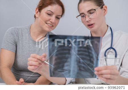The doctor consults a caucasian woman and comments on the x-ray of the lungs. The doctor consults a caucasian woman and comments on the x-ray of the lungs. 93962071