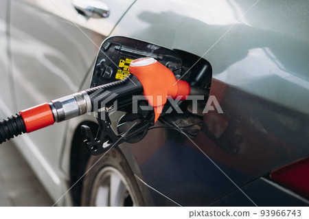 petrol pump filling fuel nozzles at gas station 93966743