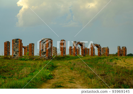 The remains of a stone column from an old building in the middle of a field on a sunny spring day. City Smiltene, Latvia. Old brick stonehenge 93969145