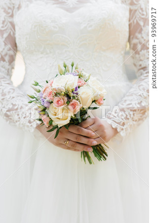 Beautiful wedding colorful bouquet in the hands of the bride. Wedding ring on the finger 93969717