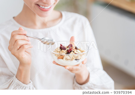 Middle woman eating granola 93970394