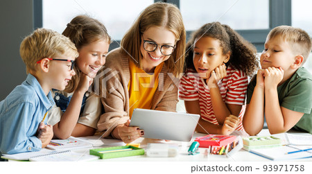 Teacher and students watching video together in school Teacher and students watching video together in school 93971758