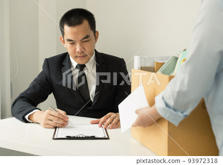 Desperately fired female office worker employee hands her employer her resignation letter and packs her belongings in a cardboard box concept dismissal and unemployment Desperately fired female office worker employee hands her employer her resignation letter and packs her belongings in a cardboard box concept dismissal and unemployment 93972318