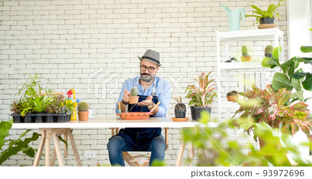 An elderly man handsome with have mustache wearing glasses is happy with tree care. is a hobby of gardening at home, living happily after retirement. Concepts nature and environment 93972696