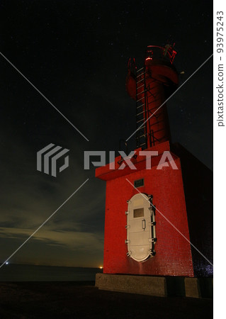 red lighthouse at night 93975243