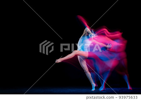Ease of movement. Tender female ballet dancer dancing solo dance over dark background in mixed neon light. Art, flexibility, inspiration and beauty concept. 93975633