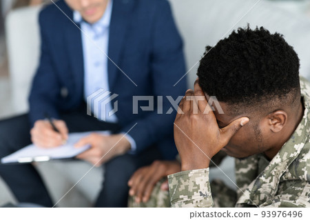 Pensive african american soldier attending psychotherapist at clinic, top view Pensive african american soldier attending psychotherapist at clinic, top view 93976496