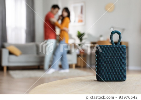 Selective focus on portable speaker over dancing couple Selective focus on portable speaker over dancing couple 93976542