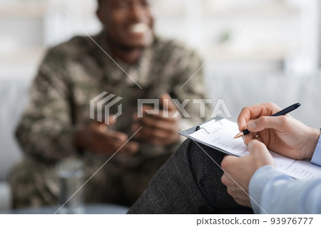 Black military man attending psychologist, blurred background Black military man attending psychologist, blurred background 93976777
