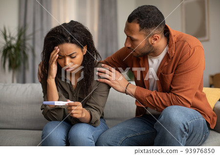 Unhappy African American Couple Holding Negative Pregnancy Test At Home Unhappy African American Couple Holding Negative Pregnancy Test At Home 93976850