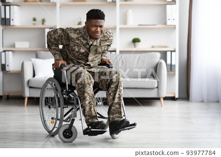 Unhappy african american veteran in wheelchair trying to get up Unhappy african american veteran in wheelchair trying to get up 93977784
