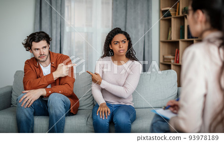 Offended sad millennial black female pointing finger at european man on meeting with psychologist 93978189