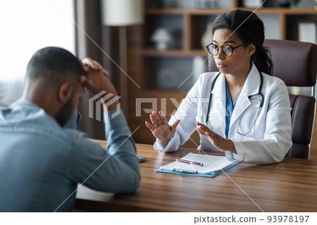 Black woman doctor consoling upset crying sick man patient 93978197