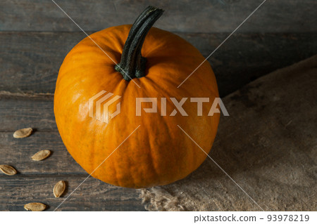 orange pumpkin on wooden boards for halloween holiday. seeds, burlap orange pumpkin on wooden boards for halloween holiday. seeds, burlap 93978219