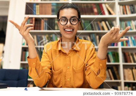 Online tutoring concept. Cheerful young woman in glasses having video conference with students Online tutoring concept. Cheerful young woman in glasses having video conference with students 93978774