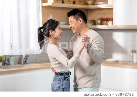 Happily married asian spouses dancing waltz at kitchen Happily married asian spouses dancing waltz at kitchen 93978788