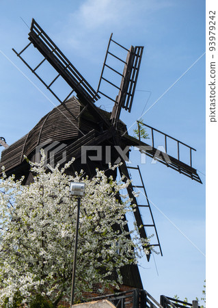 Wooden Mill on blue sky background. Old Windmill at dawn. Windmill farm. Rural landscape village on the hill in Trzew Poland 93979242
