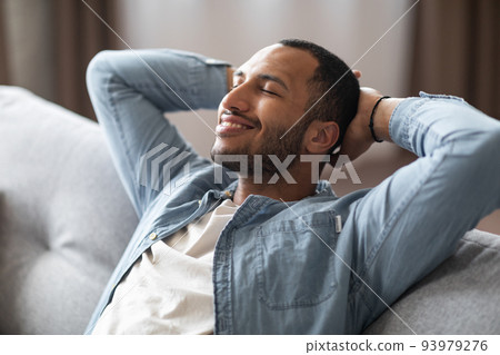 Domestic Comfort. Relaxed Young Black Man Leaning Back On Couch At Home 93979276