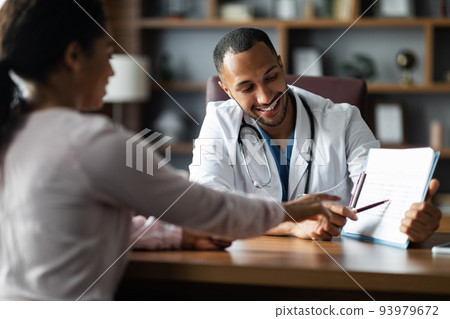 Handsome middle eastern doctor having conversation with black woman 93979672