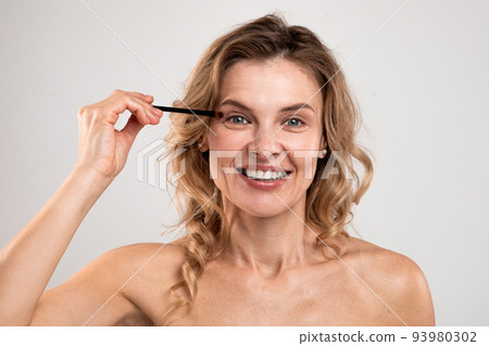 Anti-Aging Makeup. Beautiful Middle Aged Woman Holding Eye Shadow Brush Anti-Aging Makeup. Beautiful Middle Aged Woman Holding Eye Shadow Brush 93980302
