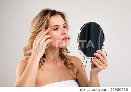 Skin Aging. Attractive Middle Aged Woman Holding Mirror And Looking At Wrinkles Skin Aging. Attractive Middle Aged Woman Holding Mirror And Looking At Wrinkles 93980716