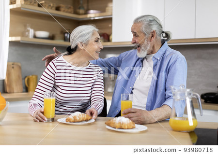 Portrait Of Happy Senior Spouses Having Snacks In Kitchen Together Portrait Of Happy Senior Spouses Having Snacks In Kitchen Together 93980718