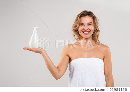 Bodycare Concept. Beautiful Middle Aged Female Holding Bottle With Moisturising Lotion Bodycare Concept. Beautiful Middle Aged Female Holding Bottle With Moisturising Lotion 93981156