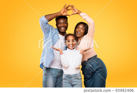 Excited black parents showing heart shape with fingers, making symbolic roof under their daughter head Excited black parents showing heart shape with fingers, making symbolic roof under their daughter head 93981406
