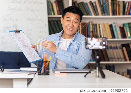 Korean Male Teacher Having Virtual Lecture Talking To Cellphone Indoor Korean Male Teacher Having Virtual Lecture Talking To Cellphone Indoor 93982751