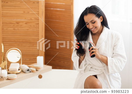 Attractive Woman Applying Hairspray Moisturizing Hair Sitting In Bathroom 93983223