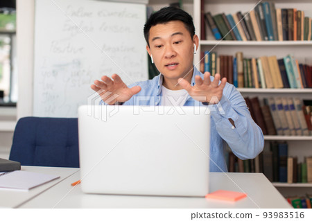Chinese E-Teacher Man Talking To Laptop Having Lecture Indoor Chinese E-Teacher Man Talking To Laptop Having Lecture Indoor 93983516