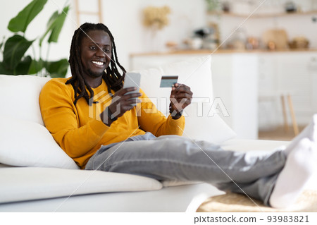Online Shopping. Happy Young Black Man Using Smartphone And Credit Card 93983821