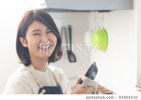 Smiling woman wiping the dishes 93984310