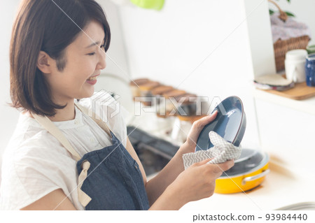 Smiling woman wiping the dishes Smiling woman wiping the dishes 93984440