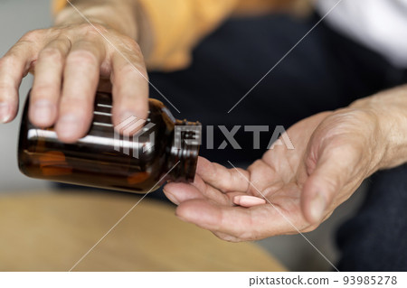 Old man hands holding medicine, closeup shot Old man hands holding medicine, closeup shot 93985278