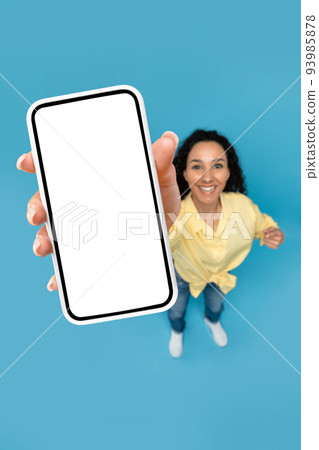 Above view of young woman pointing at mobile phone with blank screen, advertising website, offering space for ad mockup Above view of young woman pointing at mobile phone with blank screen, advertising website, offering space for ad mockup 93985878