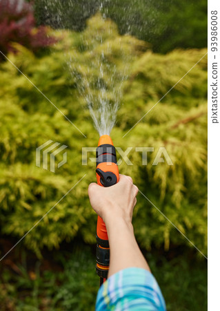 woman watering plant in garden in summer 93986008