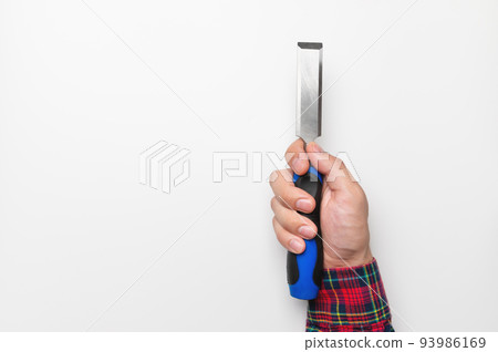 Close-up of a man's hand in a plaid shirt on a white background with a chisel, studio shot 93986169