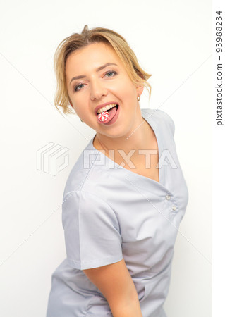Waxing, depilation, hair removal concept. Happy young caucasian beautician with candy in her mouth looking at the camera on white background 93988234
