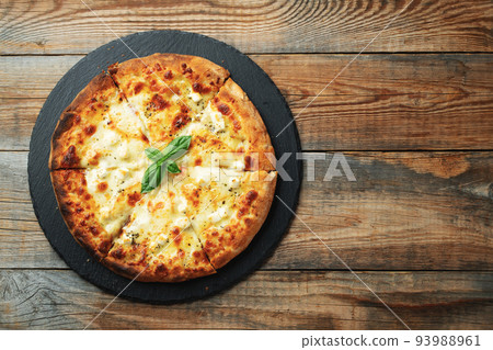 A slice of hot Italian pizza with stretching cheese. Pizza four cheeses with basil. A slice of hot Italian pizza with stretching cheese. Pizza four cheeses with basil. 93988961