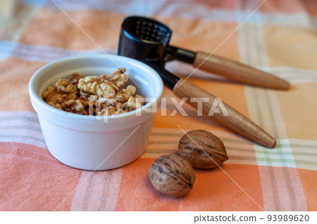 fresh walnuts with a cracker on a table fresh walnuts with a cracker on a table 93989620