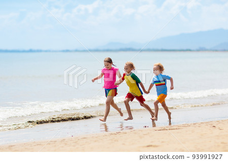 Kids playing on beach. Children play at sea. Kids playing on beach. Children play at sea. 93991927