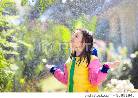 Child playing in autumn rain. Kid with umbrella. 93991943